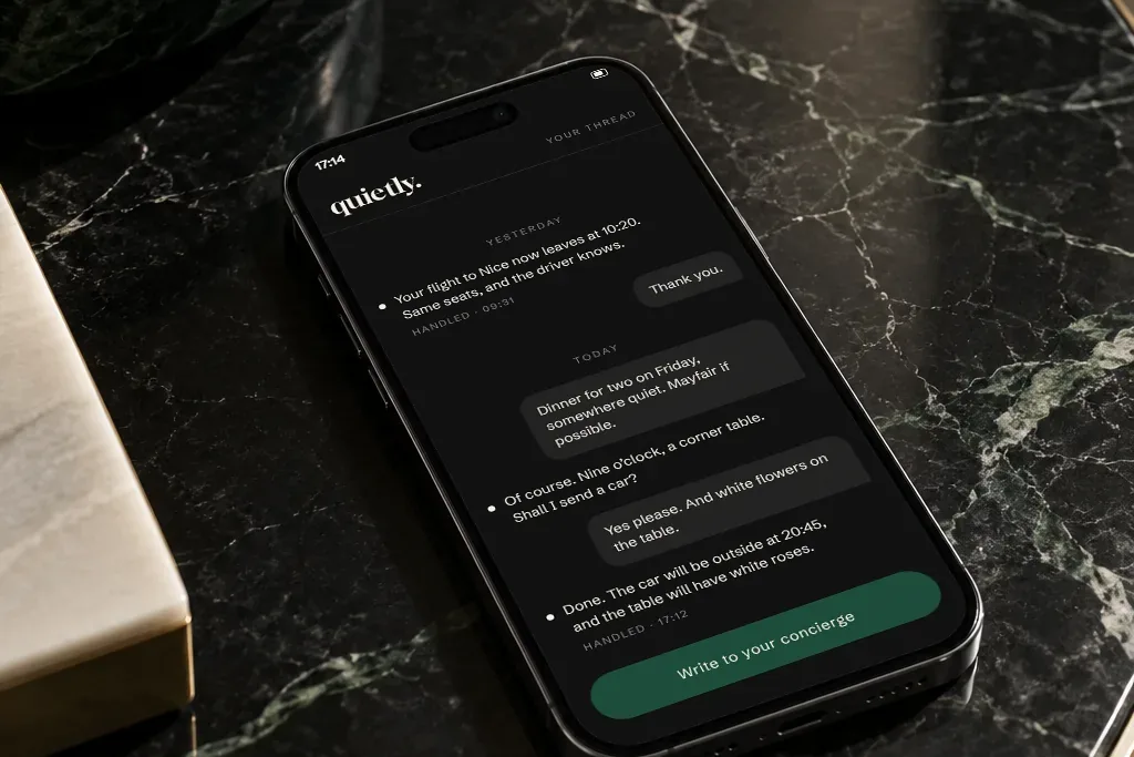 A phone on dark marble showing a request thread in the QUIETLY concierge app