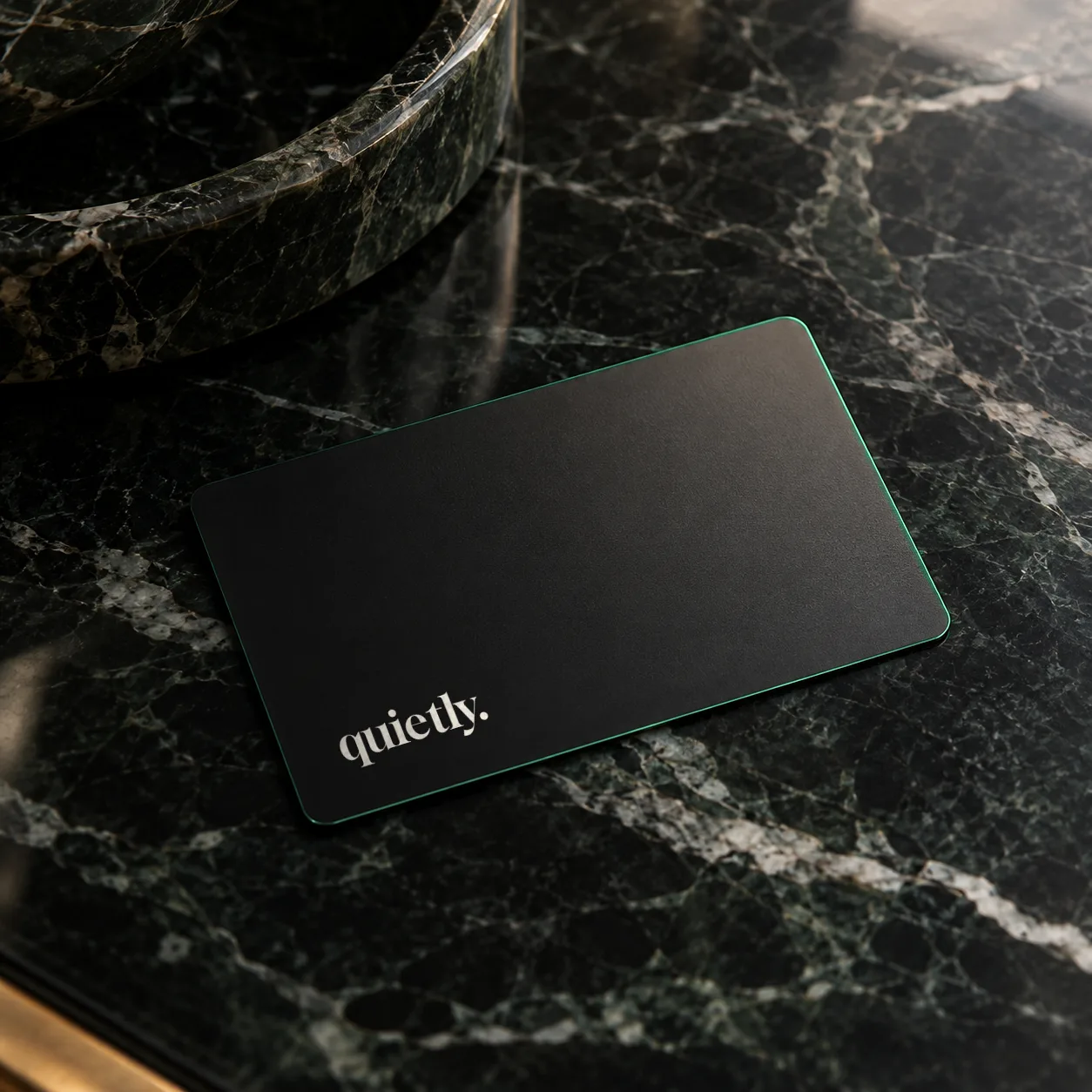 Membership card. Matte black metal, emerald edge, nothing on the back